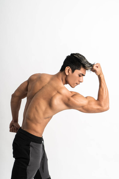 half body image of young man showing muscular biceps stand facing forward - Foto, Bild