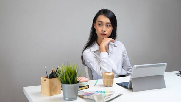 Πορτραίτο γυναίκας σχεδιάστριας που κάθεται στο γραφείο της με ψηφιακή πλακέτα, προμήθειες, γραφική ύλη και διακόσμηση - Φωτογραφία, εικόνα