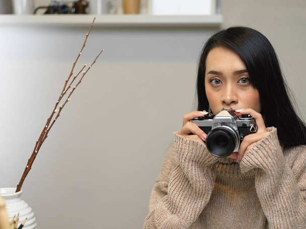 Muotokuva nuori nainen ottaa valokuvan vintage kamera työskennellessään studiossa - Valokuva, kuva