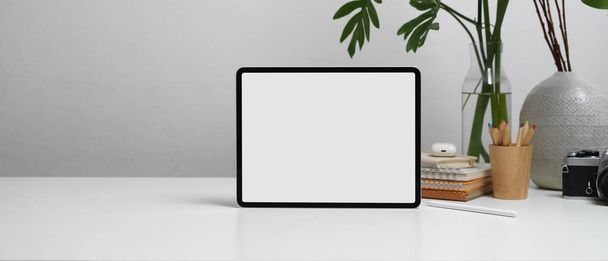 Vue rapprochée de la tablette numérique avec chemin de coupe sur la table blanche avec espace de copie, papeterie et décorations - Photo, image