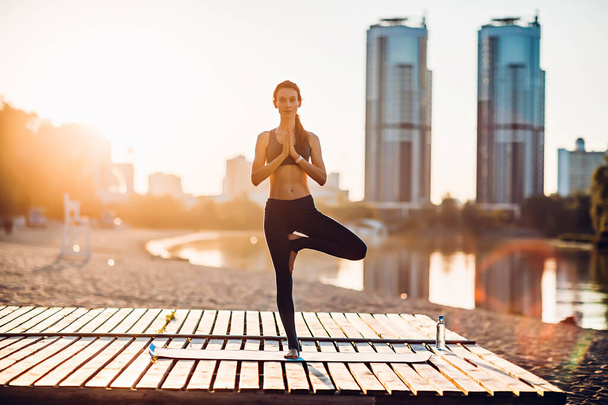 Desportista faz ioga ao nascer do sol
 - Foto, Imagem