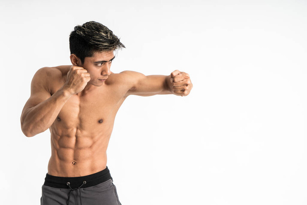 young man with muscular body with defensive movement with one hand blocking - Fotoğraf, Görsel
