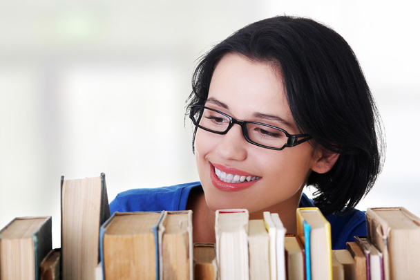 Счастливая улыбающаяся молодая студентка с книгами
 - Фото, изображение