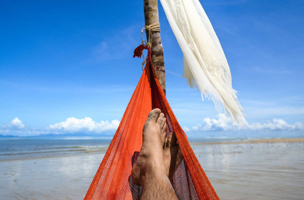 Дозвілля влітку, відпочинок на гамаку на піщаному пляжі, погляд на небо
. - Фото, зображення