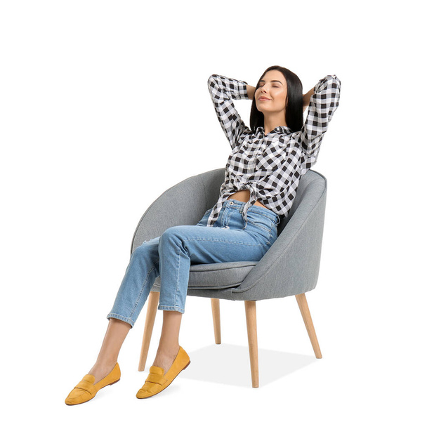 Молодая женщина отдыхает в кресле на белом фоне - Фото, изображение