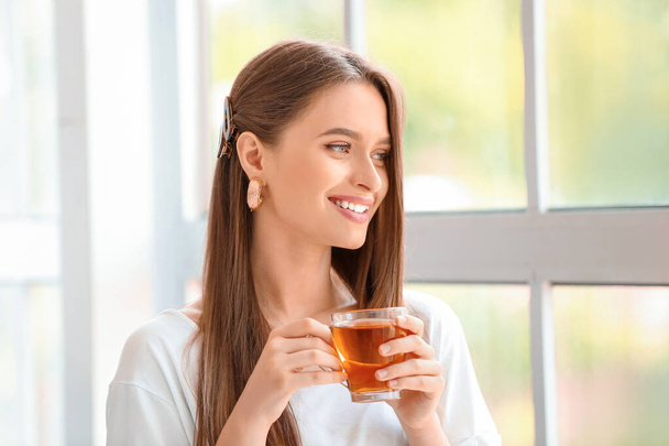Krásná mladá žena pije čaj doma - Fotografie, Obrázek