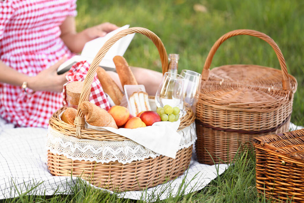 Parkta romantik piknik için içinde lezzetli yemekler ve içecekler olan sepet. - Fotoğraf, Görsel