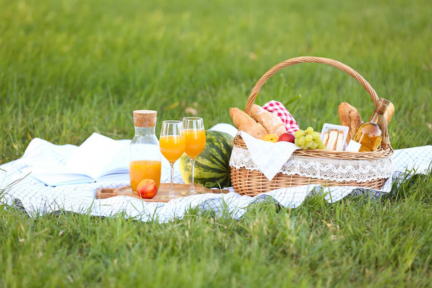 Καλάθι με νόστιμο φαγητό και ποτό για ρομαντικό πικνίκ στο πάρκο - Φωτογραφία, εικόνα