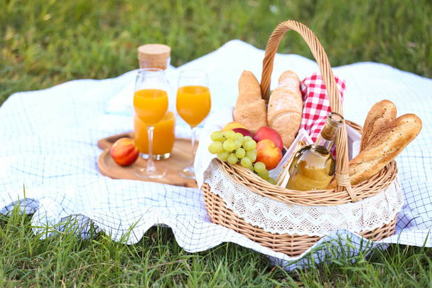 Korb mit leckerem Essen und Trinken für ein romantisches Picknick im Park - Foto, Bild