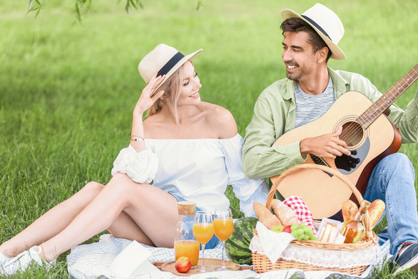 Szczęśliwa młoda para na pikniku w parku - Zdjęcie, obraz