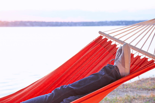 Молодий чоловік розслабляється в гамаку на відкритому повітрі
 - Фото, зображення