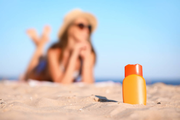 Botella de crema protector solar en arena de playa - Foto, imagen