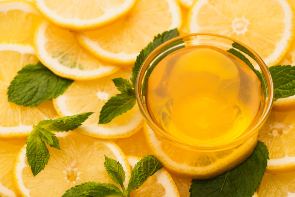tarro de miel en rodajas de limones amarillos con hojas verdes menta - Foto, Imagen