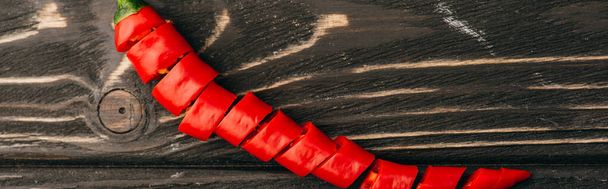 vrchní pohled na krájený červený chilli pepř na dřevěném povrchu, panoramatický záběr - Fotografie, Obrázek