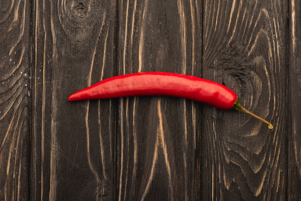 top view of spicy red chili pepper on wooden surface - Fotografie, Obrázek