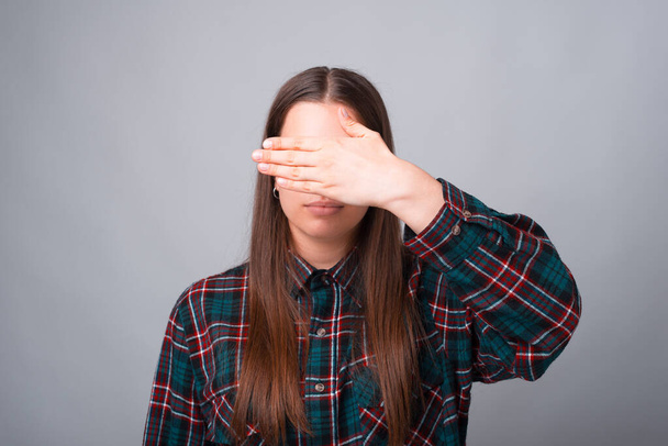 Фото молодої жінки, що прикриває обличчя долонею
 - Фото, зображення