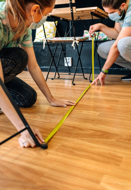 Lavoratori che misurano la distanza sociale sul pavimento - Foto, immagini