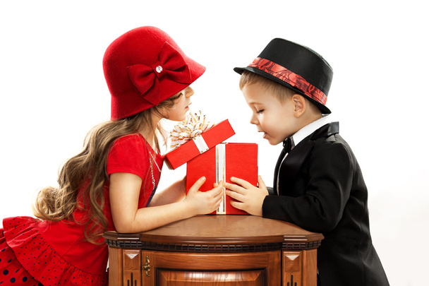 Щасливі діти відкривають подарунок
 - Фото, зображення