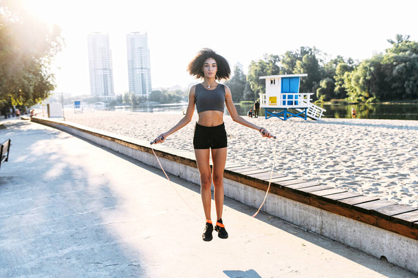 African-American girl is jumping rope outdoors - Foto, immagini