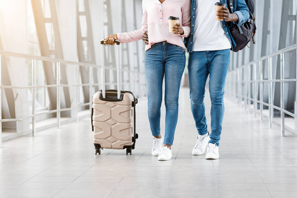 Havaalanında boş zaman. Terminalde bavullar ve kahveyle yürüyen çift. - Fotoğraf, Görsel