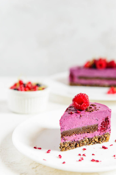A slice of cashew cake made from black currant, chocolate and green buckwheat granola. Sugar, lactose, gluten free. - Photo, Image
