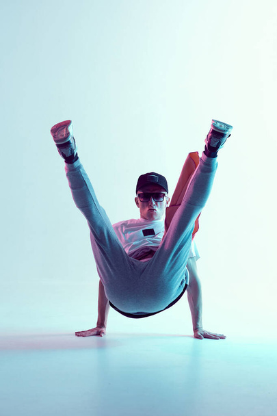 Breakdancer young man stands on hands in neon light. Dance school poster. Battle competition announcement - Фото, изображение