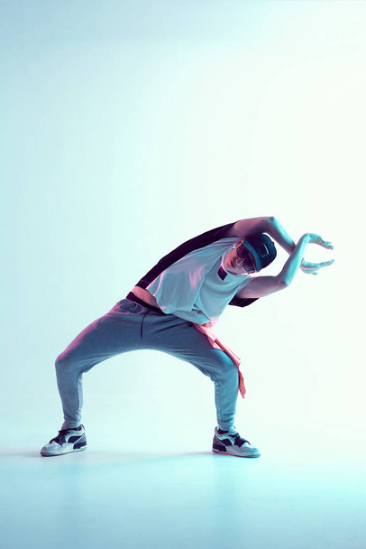 Cool young breakdancer guy dance in studio in neon light. Dance school poster - Фото, изображение