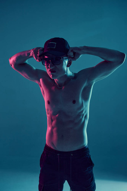 Cool young guy breakdancer dancing hip-hop without shirt in neon blue light. Dance school poster - Φωτογραφία, εικόνα