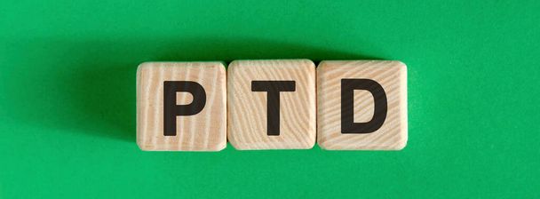 PTD text concept on wooden beige cubes on a green background - Фото, изображение