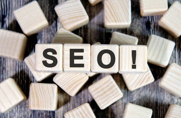 SEO text on wooden cubes on a wood background - Foto, imagen
