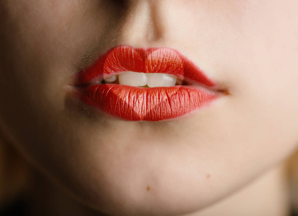 Close up of a young woman's face with heart drawn on her lips. - 写真・画像