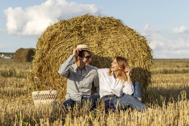 Portrait of lovers on hay background. Happy smiling couple in love during a picnic in field. - Photo, Image