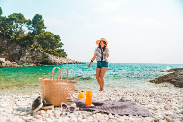 plage trucs chapeau de paille et sac avec des nageoires et crème de protection solaire à bord de la mer femme sur fond - Photo, image