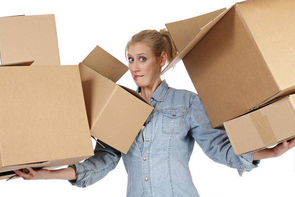 young and pretty caucasian blonde woman moving with cardboard boxes on white isolated background - Foto, afbeelding