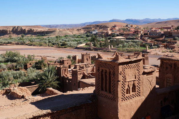 Hoge hoek uitzicht op bruine Ait Benhaddou en zonnige blauwe skyline. Oude berber kasbah in Marokko bij Ouarzazate. Ait Benhaddou is een versterkte stad, of paleis ksar - Foto, afbeelding