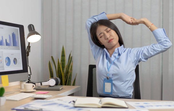 アジアの実業家は残業後リラックスしているオフィスで働く幸せな女性は仕事が終わった後に仕事で休んでいる. - 写真・画像