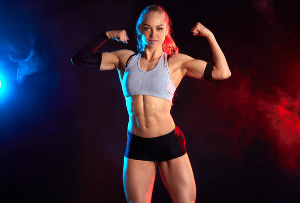 strong cheerful female bodybuilder with ponytail showing her perfect, ideal body - Valokuva, kuva