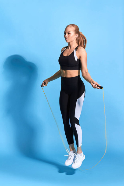 young blonde woman is keen on jumping with a rope - Foto, Imagen