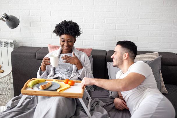 Couple au lit avec petit déjeuner tôt le matin sourire - Photo, image