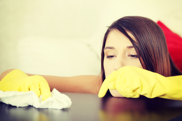 Tired young woman cleaning furniture table - Photo, image