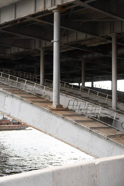  Steel structures of the bridge, water surface and granite parapet are visible - Photo, image