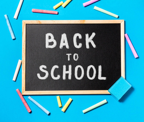 The concept of going back to school. Chalk inscription back to school on a chalkboard on a blue background. Space for text. The view from the top - Foto, Imagem