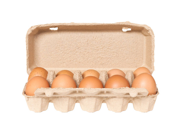 Ovos de galinha marrom em caixa de ovo de papel isolado em fundo branco. Vista superior com espaço de cópia. Conceito de alimentação saudável - Foto, Imagem