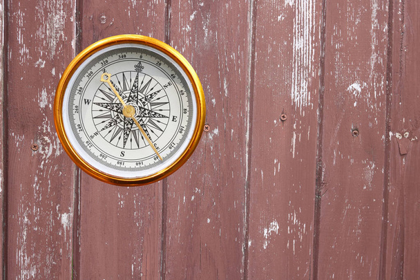 круглый компас на деревянном фоне как символ туризма с компасом, путешествия с компасом и активного отдыха с компасом - Фото, изображение