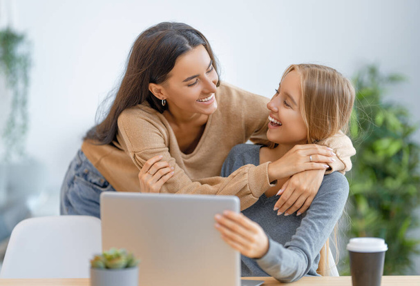 Two happy young women using laptop. Friends spending time together. - Foto, Imagem