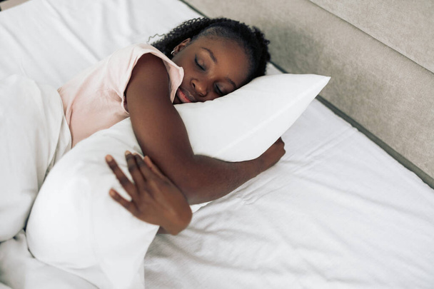Young girl hugging a pillow while sleeping - 写真・画像
