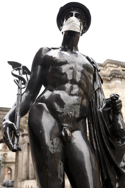 Mercurial posąg na Glasgow ulicy został przekształcony w symbol koronawirusu (covid 19) przez noszenie maski ochronnej. - Zdjęcie, obraz