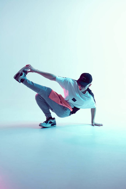Stylish young breakdancer guy dancing hip-hop in neon light on the floor. Dance school poster - Zdjęcie, obraz