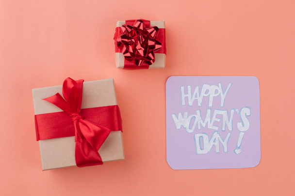 Χαρούμενη γυναικεία ημέρα επιθυμία και κουτιά δώρων με κόκκινη κορδέλα. - Φωτογραφία, εικόνα