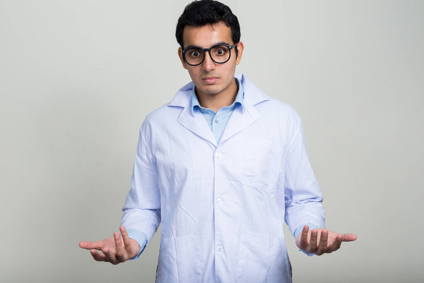 Studio shot of young handsome Indian man doctor against white background - Foto, Bild